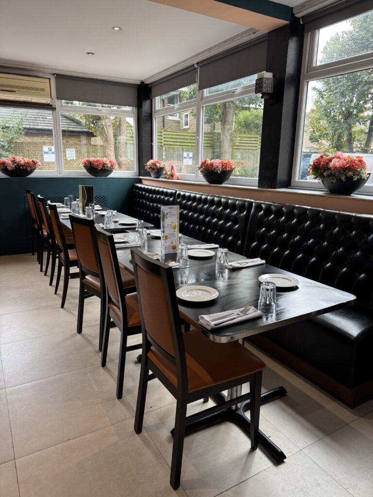 Modern-interior-dining-room-with-leather-booth-seating-and-window-views-at-Cinnamon-Lounge.