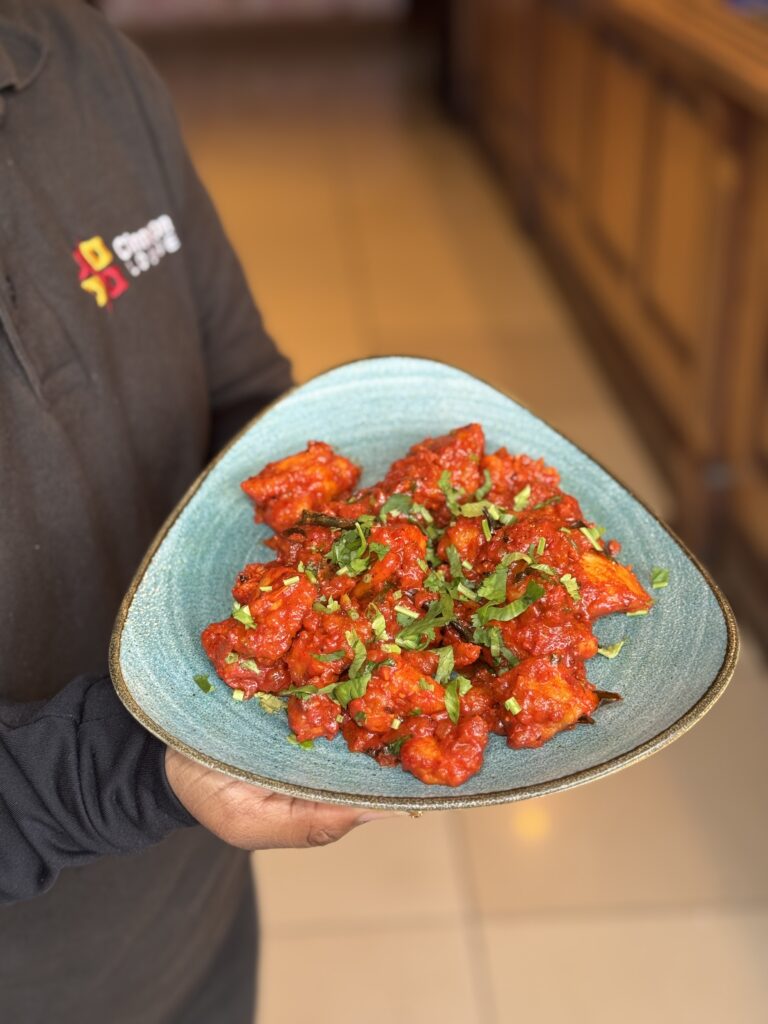 Spicy Indo-Chinese chicken 65 garnished with fresh cilantro served at Cinnamon Lounge.