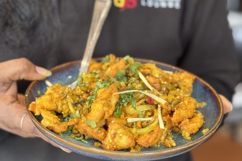 Crispy-fried-chicken-bites-garnished-with-fresh-ginger-and-cilantro-served-at-Cinnamon-Lounge.